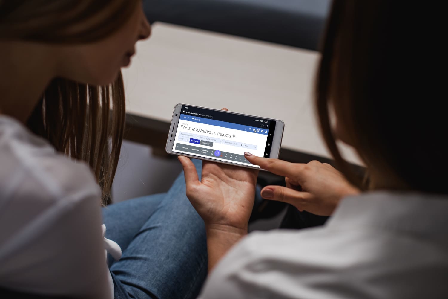 Dwie osoby przeglądają panel RCPonline na telefonie